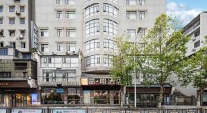 a large white building with windows on a city street at James Joyce Coffetel·Hengyang Jiefang Road Xianfeng Dock in Hengyang