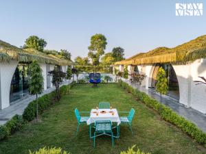 a patio with a table and chairs in a yard at StayVista at Rissaca Crown with Bonfire in Jaipur +48 photos