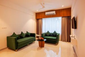 a living room with two green couches and a window at Amity's Courtyard in Jāmb