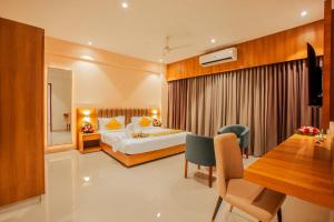 a hotel room with a bed and a dining table at Amity's Courtyard in Jāmb