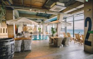 a restaurant with a pool and tables and chairs at Tropical Hideaway in Seogwipo