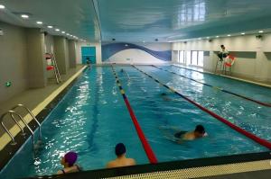 a group of people swimming in a swimming pool at Shanghai Manhattan Hotel Minhang in Shanghai