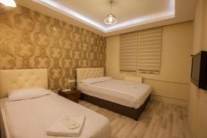 a hotel room with two beds and a television at Hotel seven park in Nevsehir