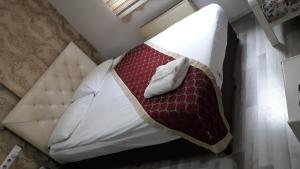 a bed with a red and white blanket on it at Hotel seven park in Nevsehir +1 photo