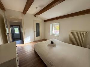 a bedroom with a large white bed and a window at L'escapade Beaujolaise in La Chapelle-de-Guinchay