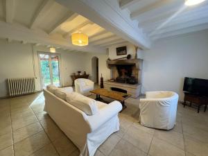 a living room with two white couches and a fireplace at L'escapade Beaujolaise in La Chapelle-de-Guinchay