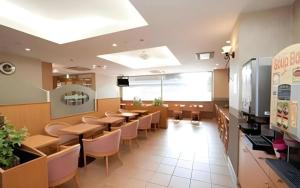 Un comedor con mesas y sillas en un restaurante. en Smile Hotel Nishiakashi, en Hayashi