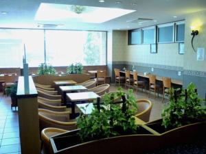 Un comedor con mesas y sillas y plantas. en Smile Hotel Nishiakashi, en Hayashi 110 fotos más