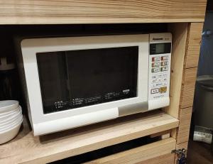 a microwave oven sitting on a shelf in a cabinet at Yokosukanominpaku Iriyamazu & Nariyamazu - Vacation STAY 18954 in Yokosuka