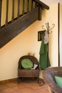 Una habitación con una silla con una almohada verde. en Apartamentos Santillana del Mar, en Santillana del Mar