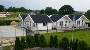 a row of white houses with black roofs at Komodor - OZONOWANE domki in Ustronie Morskie