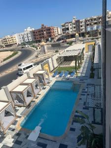 a swimming pool with chairs and tables and a building at The D9 Luxury Suites - Hurghada in Hurghada