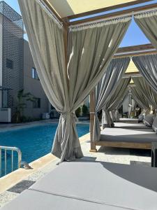 a row of beds on a patio next to a pool at The D9 Luxury Suites - Hurghada in Hurghada +32 photos