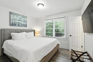 a bedroom with a large white bed and a window at Athenian Haus with Grill in Athens