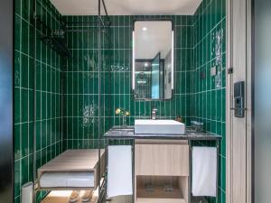 a green tiled bathroom with a sink and a mirror at Orange Hotel Beijing Zhongguancun Software Park in Beijing +37 photos