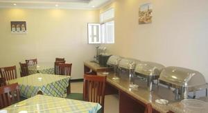 een restaurant met een bar met stoelen en tafels bij GreenTree Inn Zhangjiakou Xuanhua Bus Station Shell Hotel in Dingfangshui