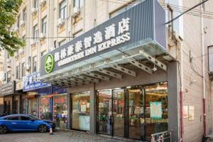 a store with a sign on the side of a building at GreenTree Inn Shanghai Luojing Express Hotel in Luojing