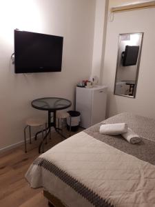 a bedroom with a bed and a television on the wall at לינה במרכז - Accommodation in the center in Petaẖ Tiqwa