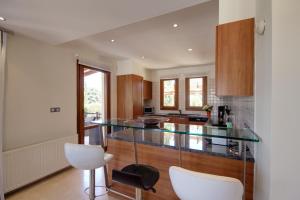 a kitchen with a glass counter top and wooden cabinets at Villa UNIDERA in Kouklia