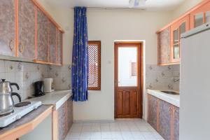 a kitchen with wooden cabinets and a blue curtain at Flower Villa Apart in Kemer