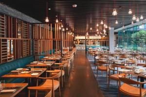 a restaurant with wooden tables and chairs and lights at 7 Days Inn Hami Baofeng Market in Qumul