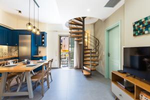 a dining room with a table and a spiral staircase at Philoxenia Residences in Panormos Rethymno