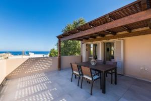 a patio with a table and chairs on a balcony at Philoxenia Residences in Panormos Rethymno