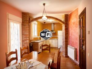 a kitchen with a wooden table and a dining room at Casa rural zaragoza in Almonacid de la Sierra