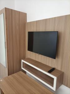 uma televisão de ecrã plano montada numa parede de madeira em Hotel Sanwariya em Gandhinagar