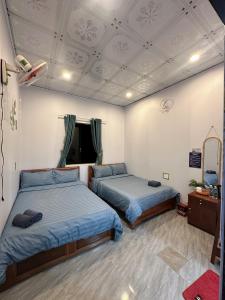 een kamer met 2 bedden en een spiegel bij Homestay Rừng Phố 2 - Măng Đen in Kon Plong +34 foto's