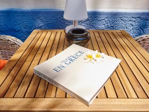 a book on a table with flowers on it at Villa Sanyan - Adults Only in Rhodes Town