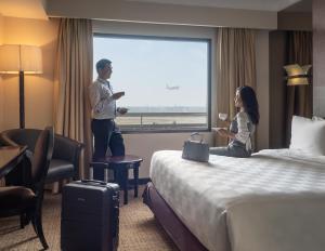 a man and a woman standing in a hotel room at Jakarta Airport Hotel in Rawabagol
