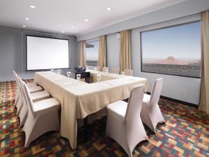 a conference room with a long table and white chairs at Jakarta Airport Hotel in Rawabagol
