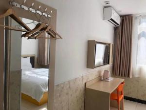 een hotelkamer met een bed, een bureau en een spiegel bij 7 Days Inn·Taixing Wenchang Road in Taixing