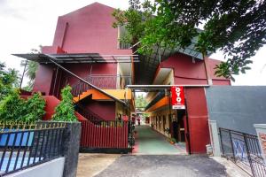 a red building with a red fence in front of it at OYO 1720 A2b Residence in Malalayang