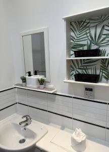 ein weißes Badezimmer mit Waschbecken und Spiegel in der Unterkunft City Centre Apartment - Free Parking - Sleeps 4 in Exeter