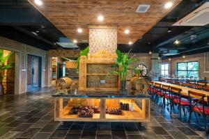 a restaurant with a bar with red chairs at San Signature - Suối Ngọc Retreat in Tien Xuan