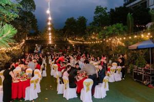 a group of people sitting at tables at a party at San Signature - Suối Ngọc Retreat in Tien Xuan