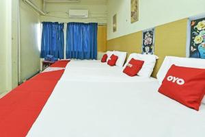a room with a large bed with red and white pillows at SPOT ON 90625 Super Green Grass Hotel in Yong Peng
