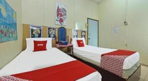 a room with two beds with red and white sheets at SPOT ON 90625 Super Green Grass Hotel in Yong Peng