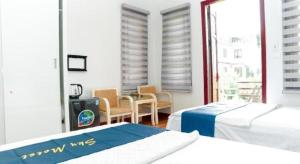 a bedroom with two beds and a table and chairs at SKY HOTEL - KHÁCH SẠN BẮC NINH in Bồ Sơn +50 photos