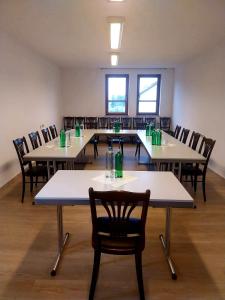 una sala grande con mesas y sillas con bebidas encima. en Hotel Sonnenkeller, en Neu-Ulm