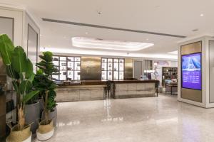 a lobby of a store with a large screen at Mercure Ordos Downtown in Ordos