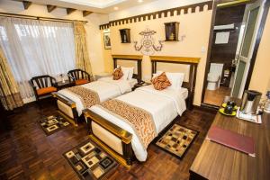 a bedroom with a bed, desk, chair and lamp at Hotel Encounter Nepal & Spa in Kathmandu
