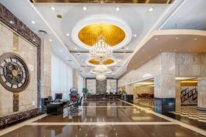 een grote lobby met een kroonluchter en een groot gebouw bij CP Peninsula Hotel in Dongguan +284 foto's