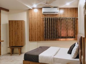 1 dormitorio con 1 cama y aire acondicionado en Hotel Signature, en Ahmedabad