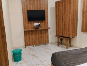 Un dormitorio con una cama y un televisor en una pared. en Hotel Signature, en Ahmedabad 2 fotos más