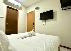 a white dog laying on a bed in a room at Swing & Pillows - Salak Tinggi , KLIA 1 KLIA 2 in Sepang