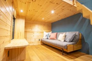 a small room with a couch in a wooden room at Lady Blue伊豆稲取 in Higashiizu