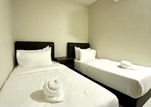 two beds in a hotel room with white sheets at Swing & Pillows - Salak Tinggi , KLIA 1 KLIA 2 in Sepang
